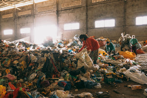 A woman picking through trash as part of a plastic waste recycling program