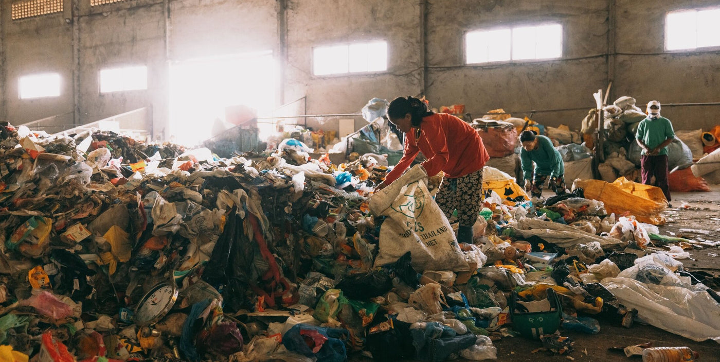 A woman picking through trash as part of a plastic waste recycling program