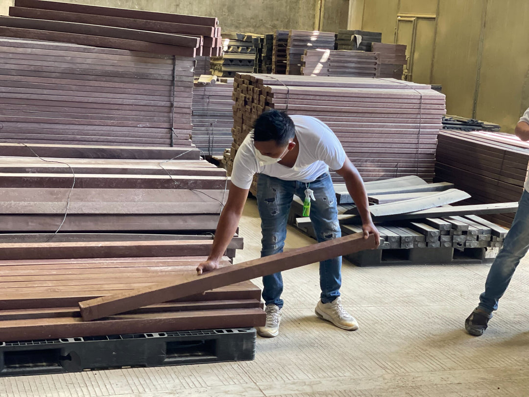 A man lifts a beam made of re-used plastics, part of a Plastic upcycling program in Davao, which is collecting and processing HDPE, PP, LDPE, and PET and turning plastic waste into useful products like benches, tables, and chairs