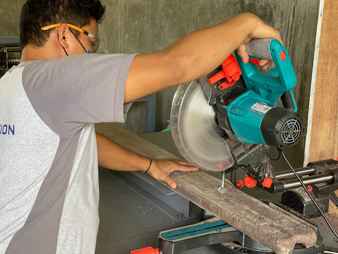 A man uses a saw to cut a beam made of re-used plastics, part of a Plastic upcycling program in Davao, which is collecting and processing HDPE, PP, LDPE, and PET and turning plastic waste into useful products like benches, tables, and chairs